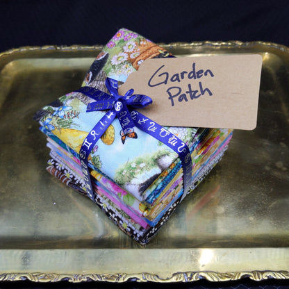 Stack of colorful fabric squares with a blue ribbon on a metallic surface