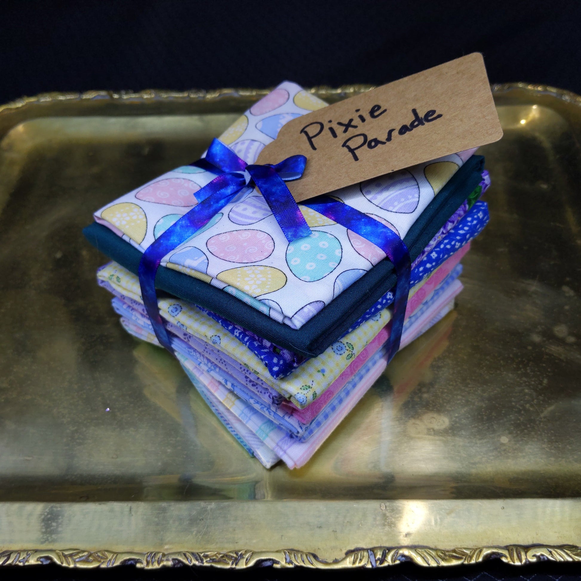 Colorful folded fabric with a blue ribbon on a metallic surface