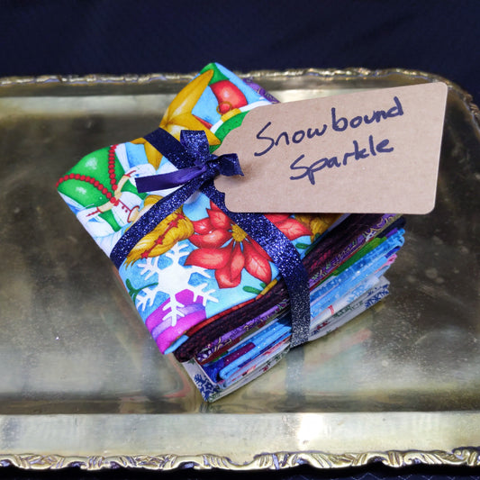 Colorful stack of fabric with ribbons and a tag on a metallic surface